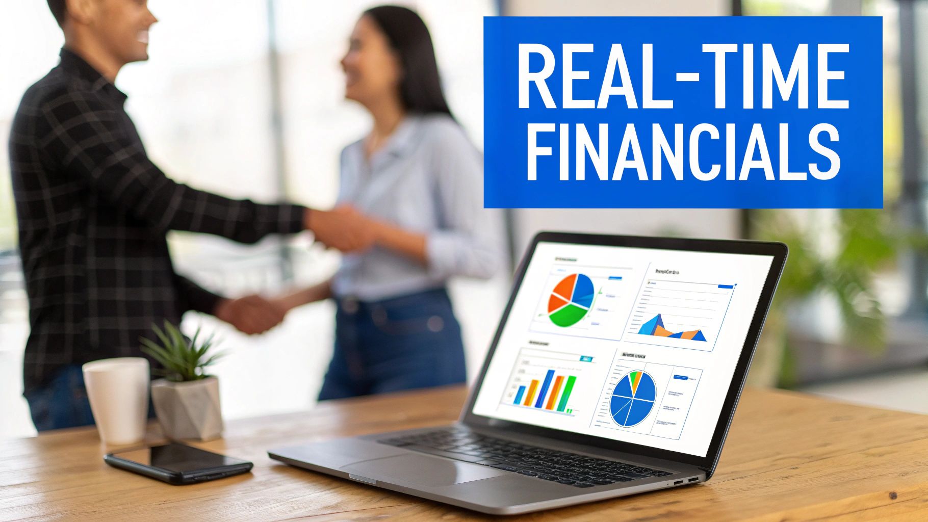 Two business people shaking hands, with a laptop on a desk displaying real-time financial data.